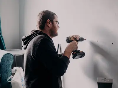 Tradesperson drilling into a wall