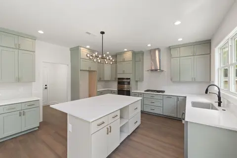 Sage green shaker kitchen with a white island
